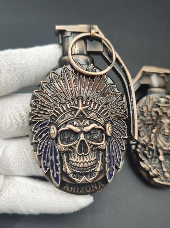 Bronze challenge coin with Native American headdress skull design and ARIZONA text, held in white gloved hands
